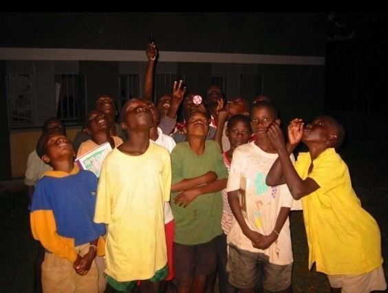 Photo of students in Uganda looking up into the night sky